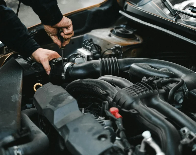 Mains d’un mécanicien sur le moteur d’un véhicule